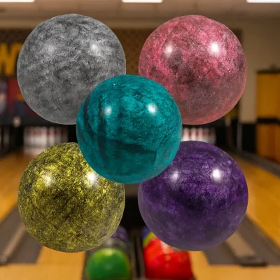 "Five marbled hi-bounce balls in gray, pink, teal, yellow, and purple floating in the foreground of a bowling alley with wooden lanes and pins in the background."