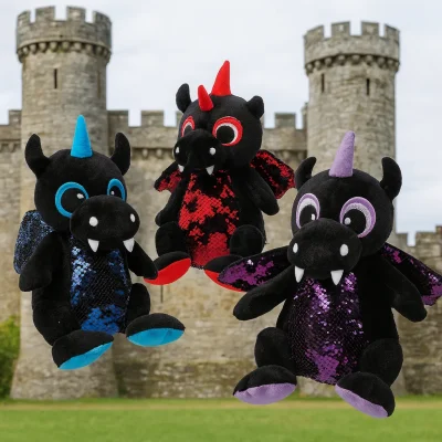 Three plush sequin dragons—one with blue accents, one with red, and one with purple—are displayed in front of tall medieval castle towers with stone walls and a cloudy sky in the background.