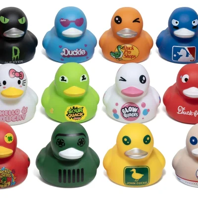 Assorted parody-themed rubber ducks displayed on a white background, featuring twelve colorful novelty duck designs inspired by pop culture, brands, sports, fast food, candy, and playful parody characters.