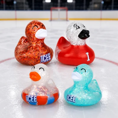ICEE glitter rubber ducks in assorted colors displayed on an ice hockey rink.